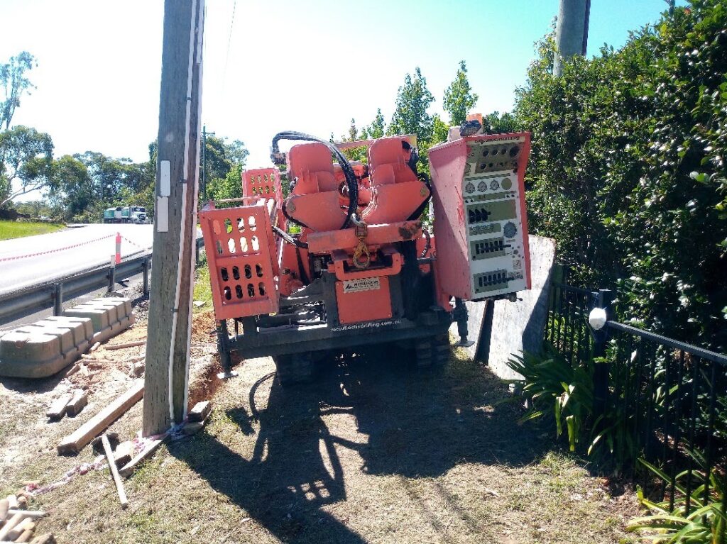 Hanjin DB8D drilling rig working on a roadside verge behind a guard rail