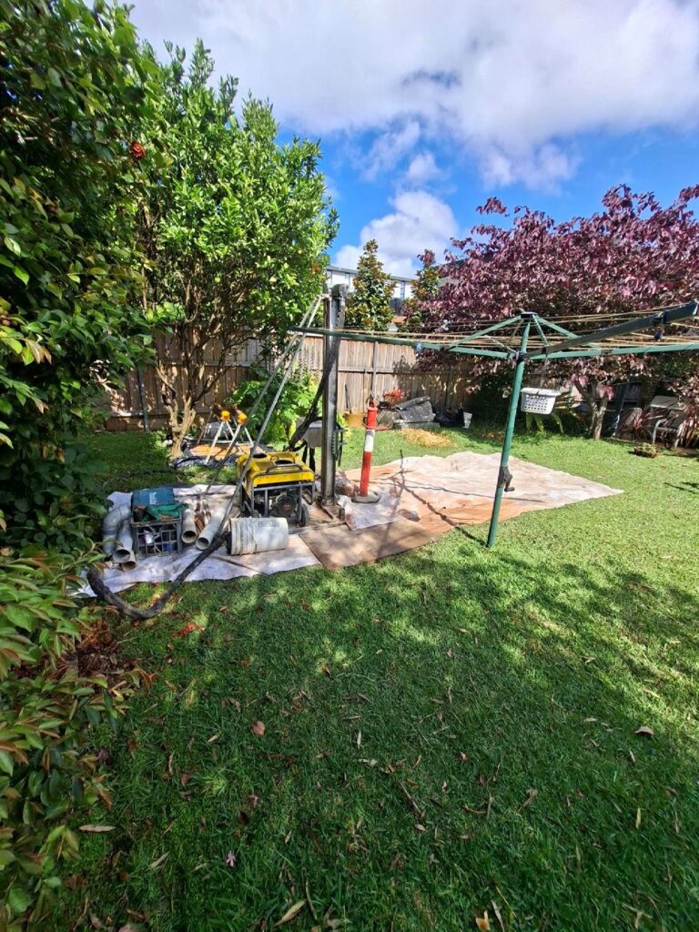 Christie hand portable drilling rig set up on a residential back lawn