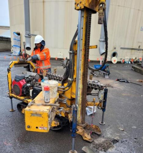 Operator working alongside the Bumble Bee tracked mini rig on a hardstand